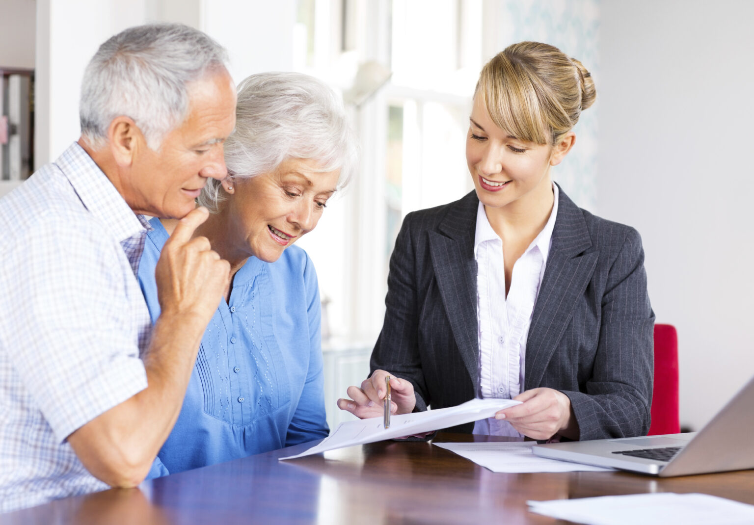 An insurance agent explains Medicare Insurance to a senior couple.
